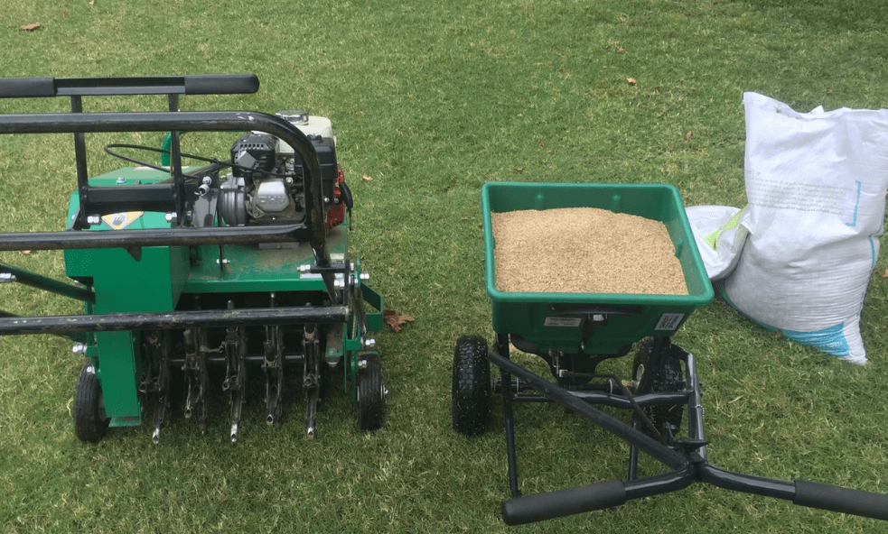 Lawn aeration and overseeding equipment — core aerator and seed spreader used by Limi Landscaping in Massachusetts