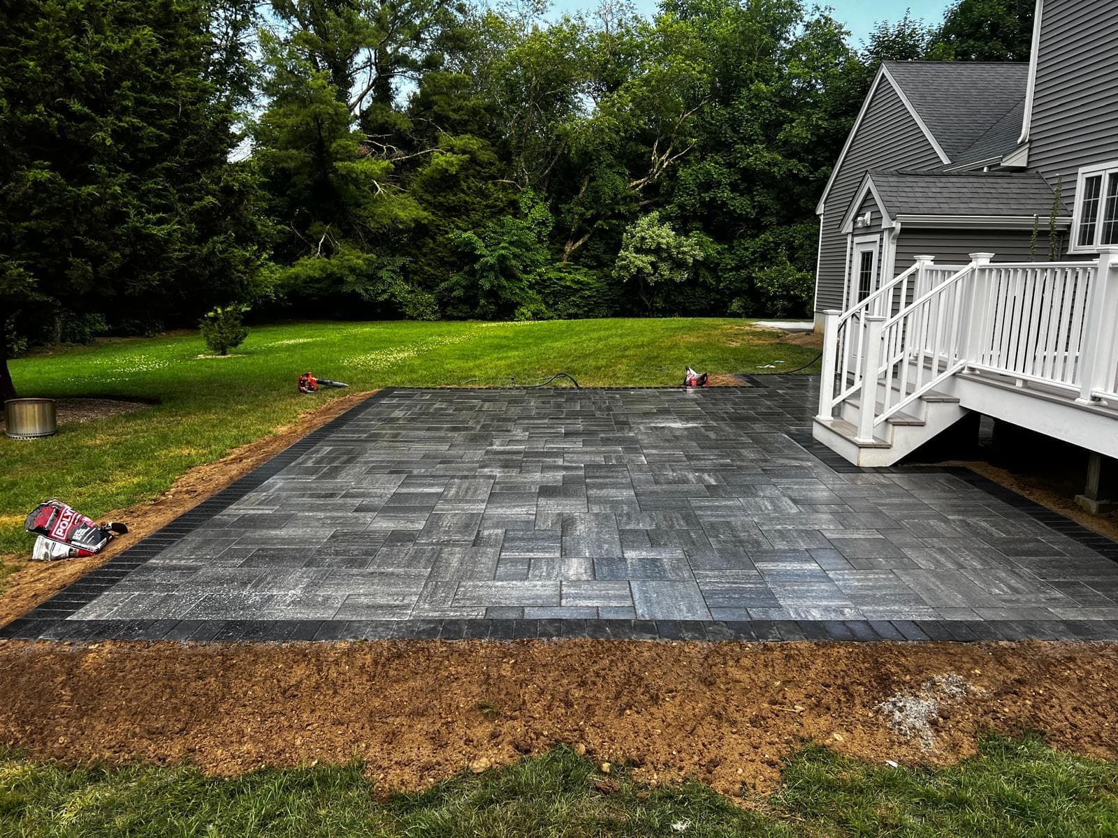 Hardscaping installation in Massachusetts — gray paver patio surrounding an inground pool by Limi Landscaping