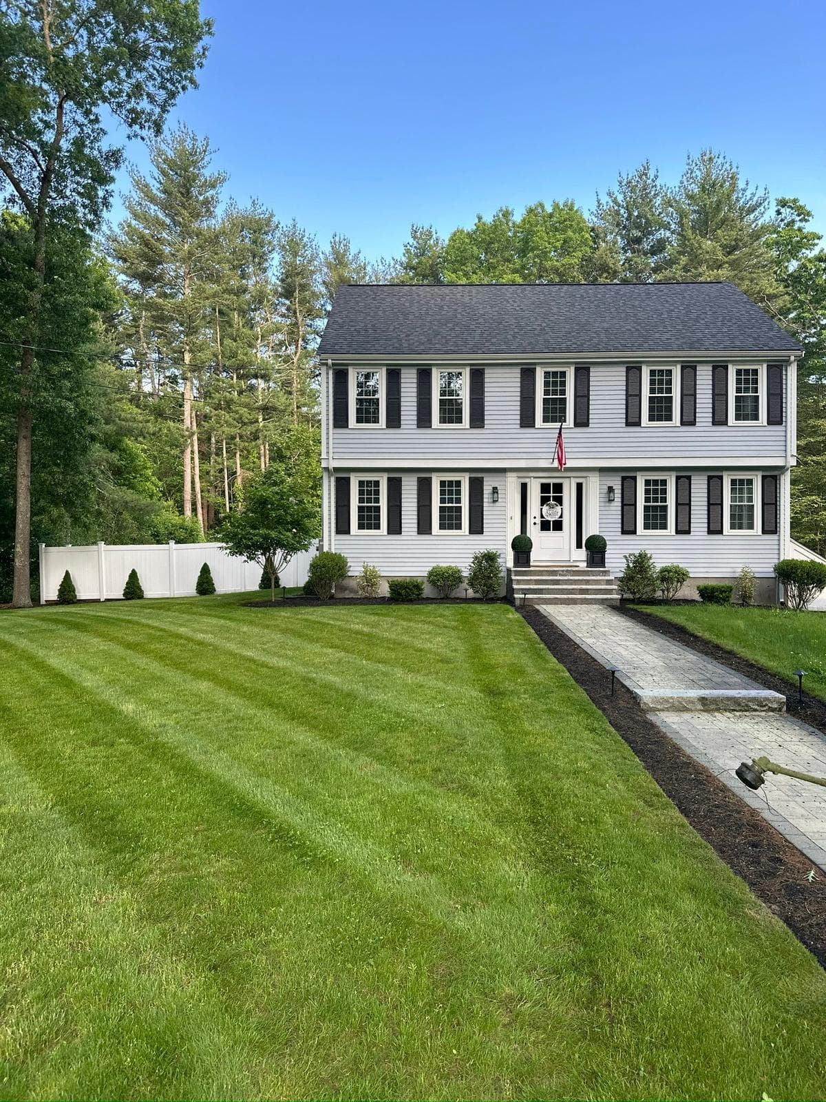 Lawn care service in Massachusetts — freshly maintained residential lawn with Limi Landscaping sign